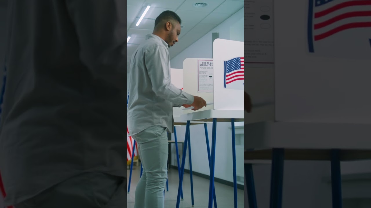 african american man takes paper ballot and walks